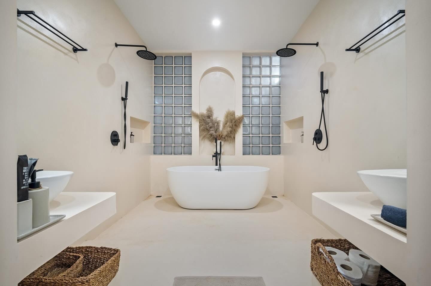 Finished Villa Kyma bathroom with freestanding bath and glass-block wall