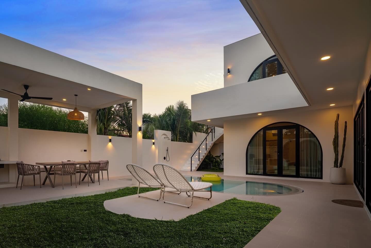 Completed Villa Kyma courtyard with pool, lawn and outdoor dining
