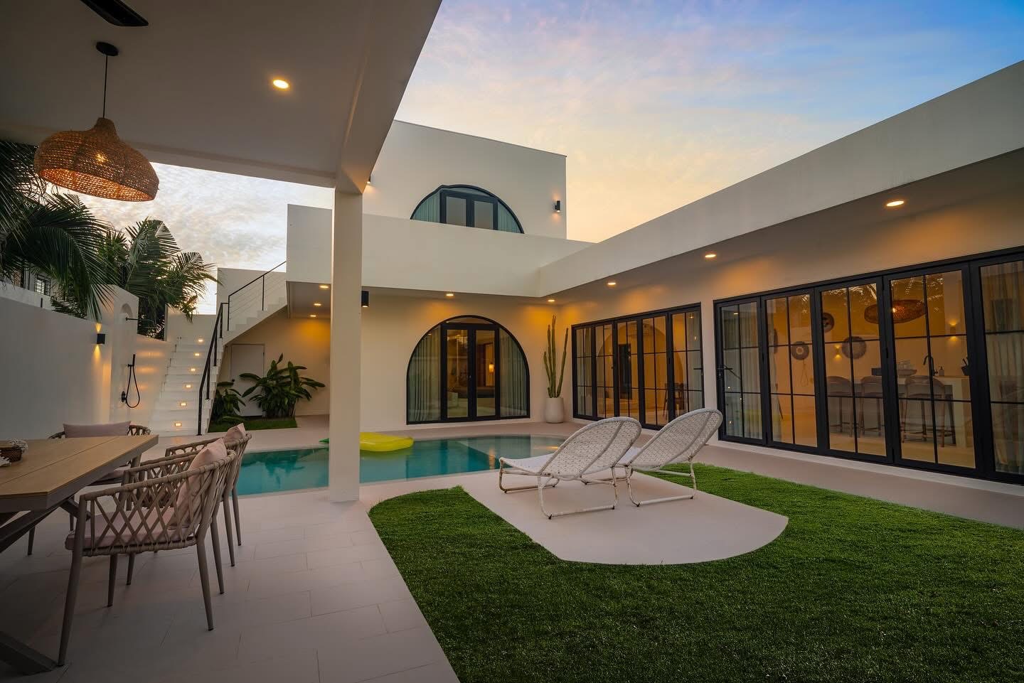 Completed Villa Kyma courtyard, pool and arched tropical architecture at sunset